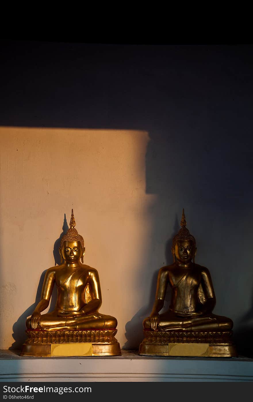 The light to the sitting Golden Buddha in the temple in Thailand