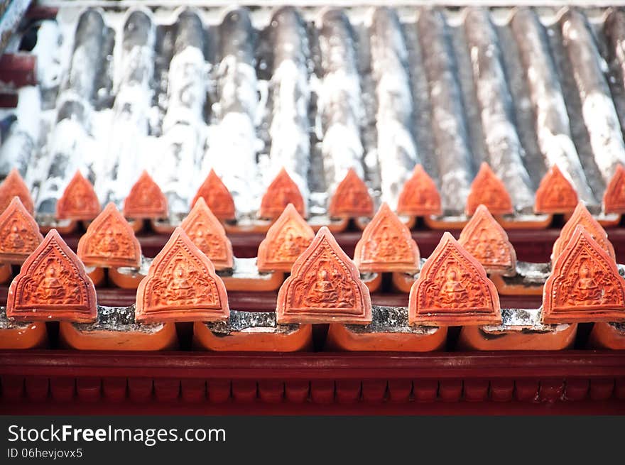 The angle pottery in Thai style decorate on the ancient roof of Temple at Yai Suwannaram temple in Petchaburi, Thailand