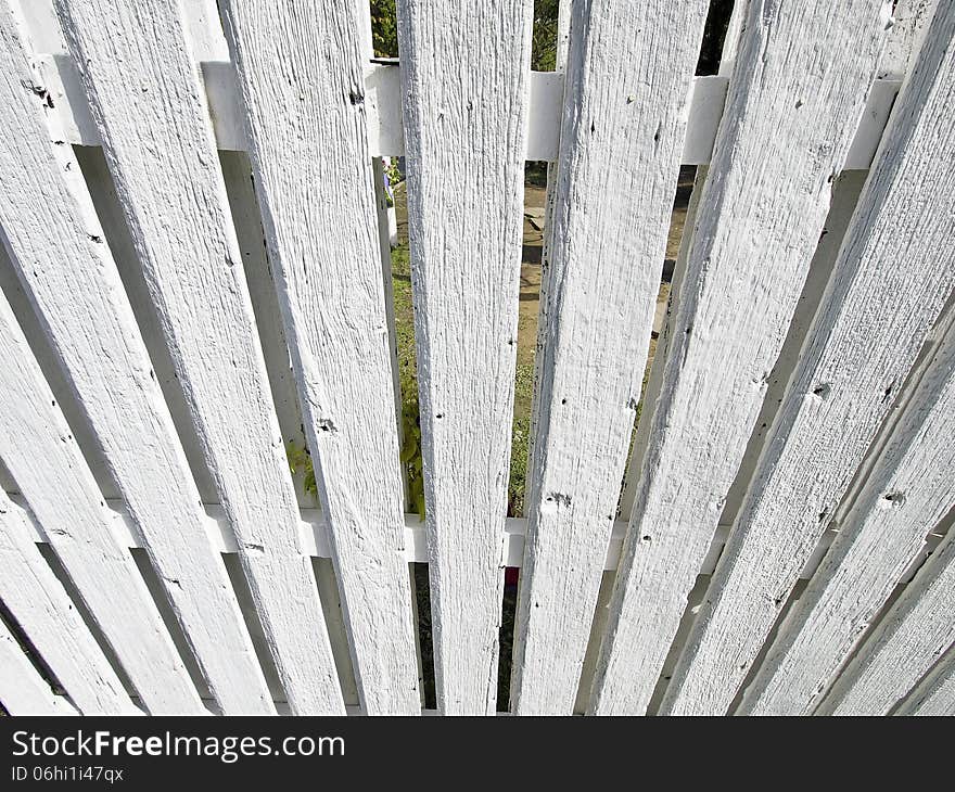 Look down perspective of white wood palisade in sunny day. Look down perspective of white wood palisade in sunny day