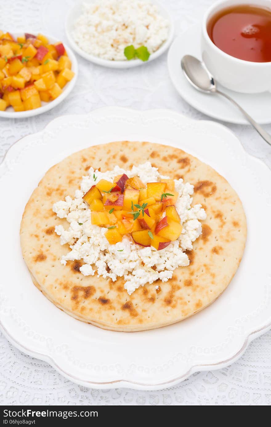 Flat bread with cottage cheese with honey, nuts, peaches and thyme for breakfast, top view