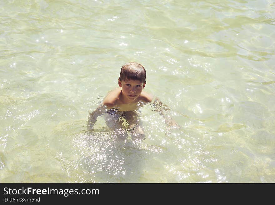 The boy popped up from the pond with clear water. The boy popped up from the pond with clear water