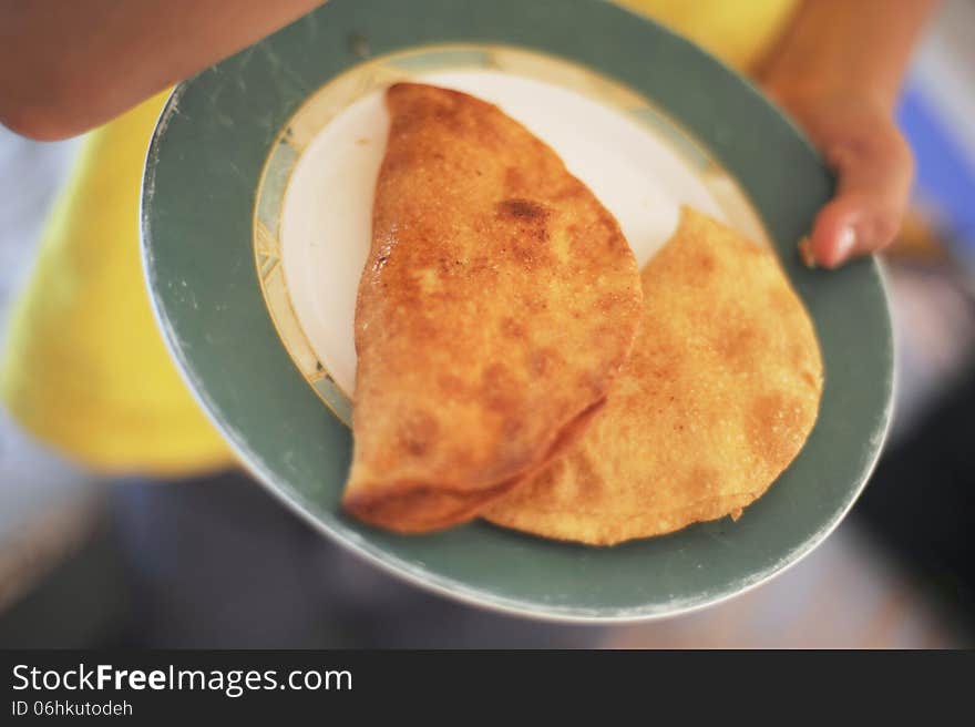 Fried pies with meat on a platter in the hands. Fried pies with meat on a platter in the hands