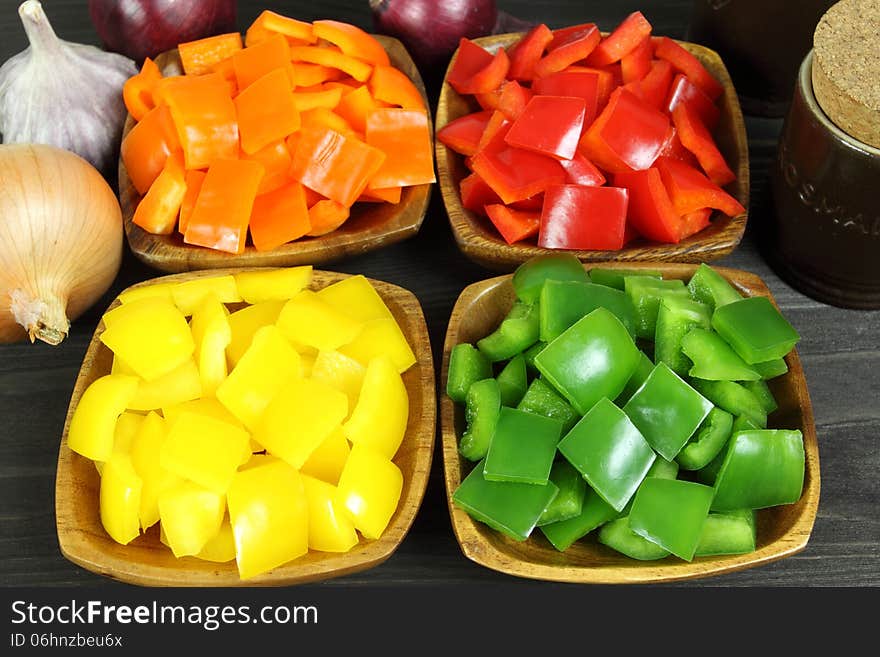 Colorful diced peppers in a wooden bowls