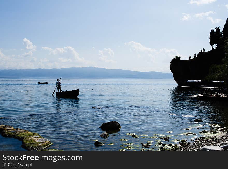 Boatsman with a cliff in the silhouette. Boatsman with a cliff in the silhouette