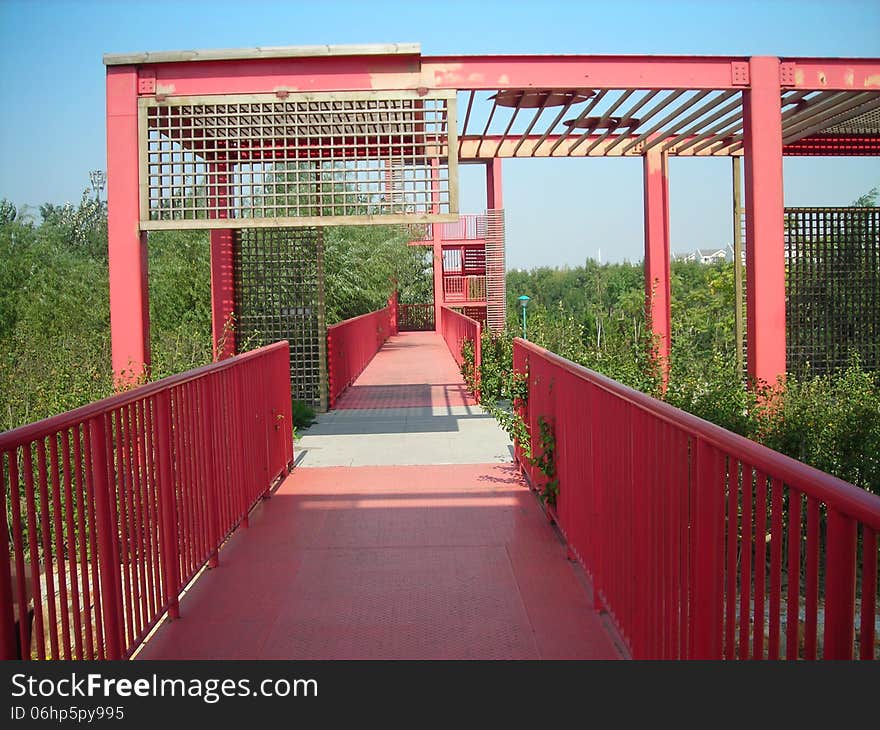 red iron bridge in city green field