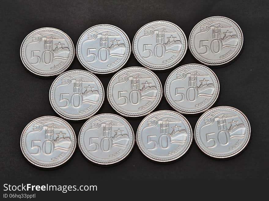 11 Freshly minted Singapore 50 cent coins (2013 version) in formation on black background. 11 Freshly minted Singapore 50 cent coins (2013 version) in formation on black background.