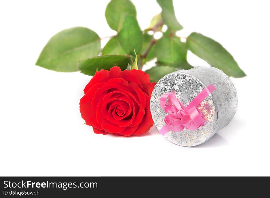 Small scarlet rose and silver gift box over white. Small scarlet rose and silver gift box over white