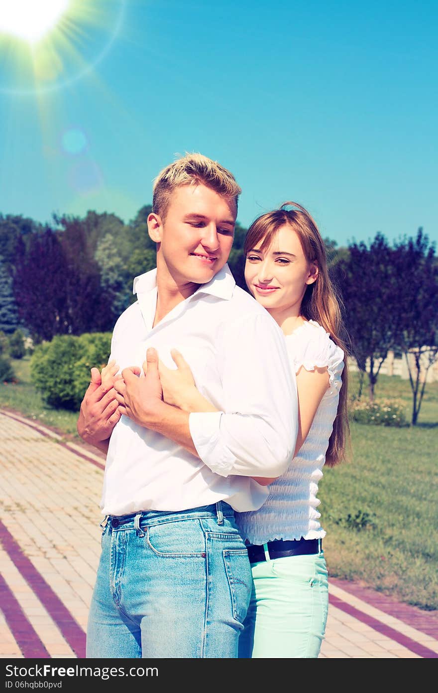 Portrait of Beautiful Young Couple in Love on nature. Man and Woman Smiling Charmingly. Young Couple Kissing Summer on Sunny Sky Background. Portrait of Beautiful Young Couple in Love on nature. Man and Woman Smiling Charmingly. Young Couple Kissing Summer on Sunny Sky Background