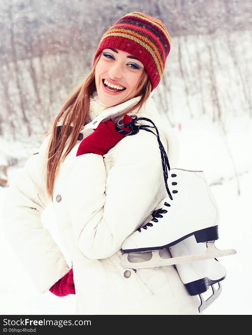 Beautiful young woman smiling happily. Winter activities at the rink with skates