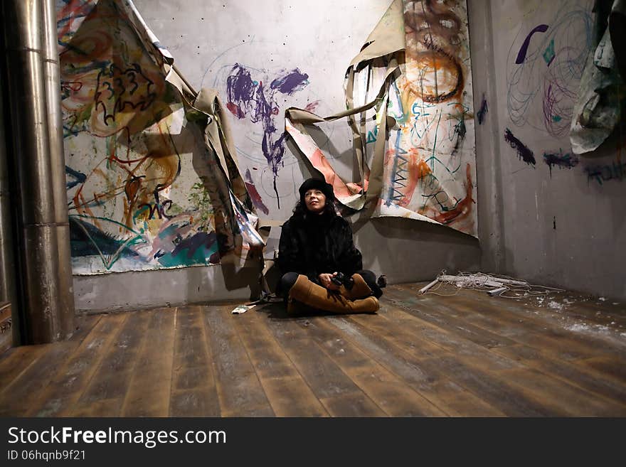 Apartment to let. Marture woman sitting on floor in old deserted apartment