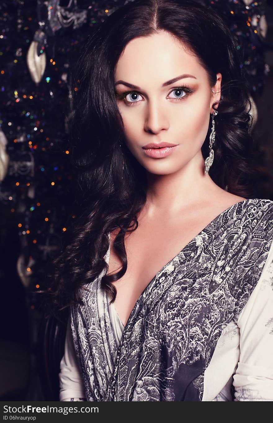 Beautiful girl with black hair with christmas tree on background