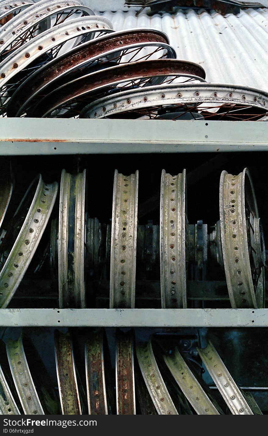 A collection of wheel rims in a New Zealand scrap yard