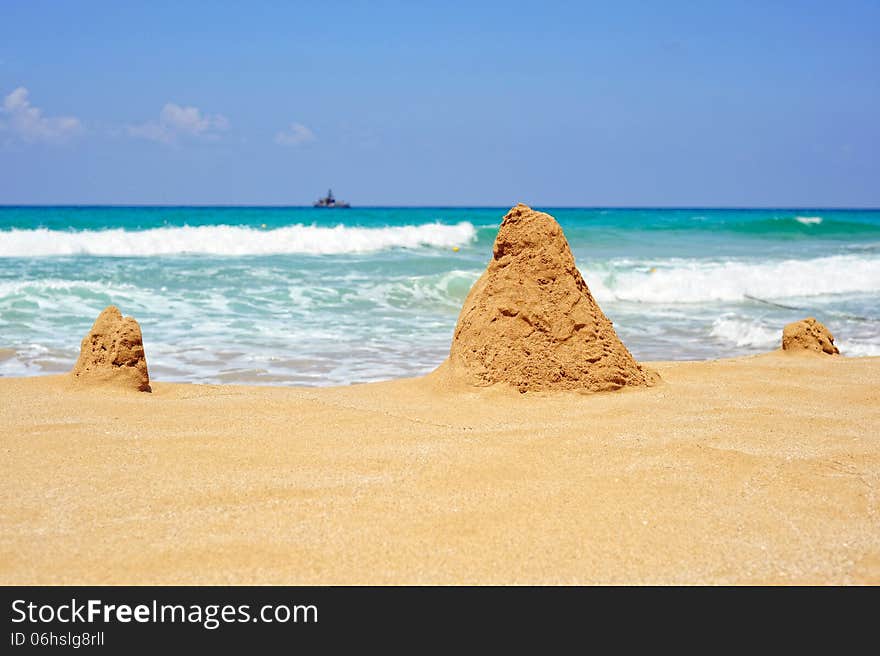 Sea ​​shore with towers of sand on a bright sunny day. Sea ​​shore with towers of sand on a bright sunny day