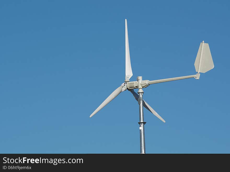 A lone wind turbine against a blue sky. A lone wind turbine against a blue sky