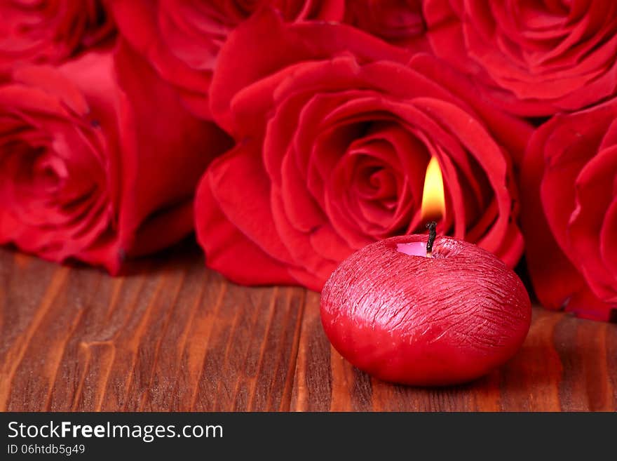 Romantic composition with red candles and roses.