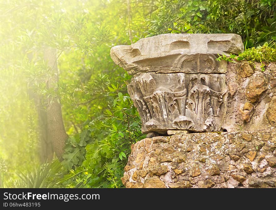 Fragmet antique column in sunlight Italy park