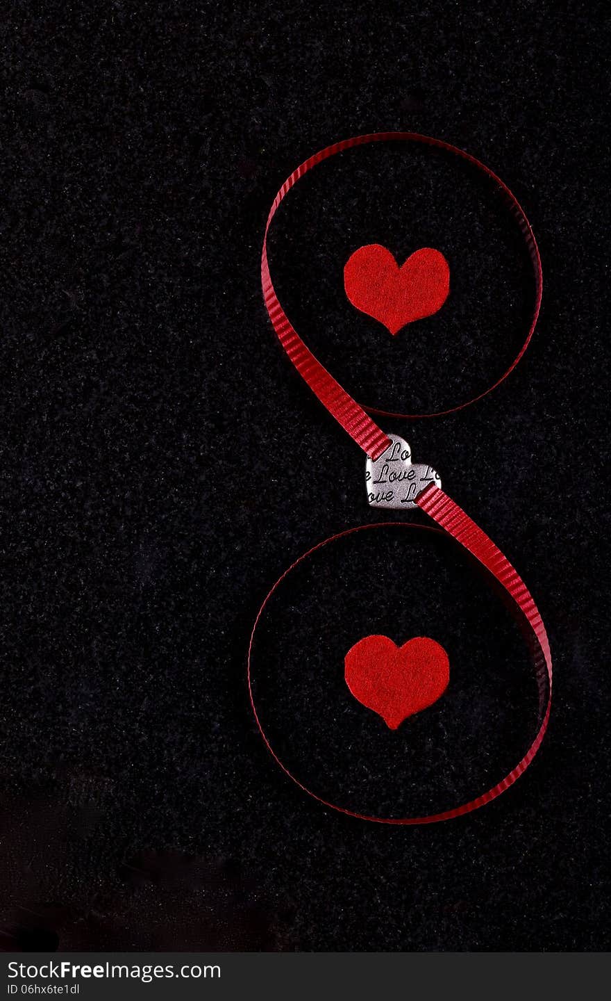 Hearts and red ribbon on black ceramic background. Hearts and red ribbon on black ceramic background