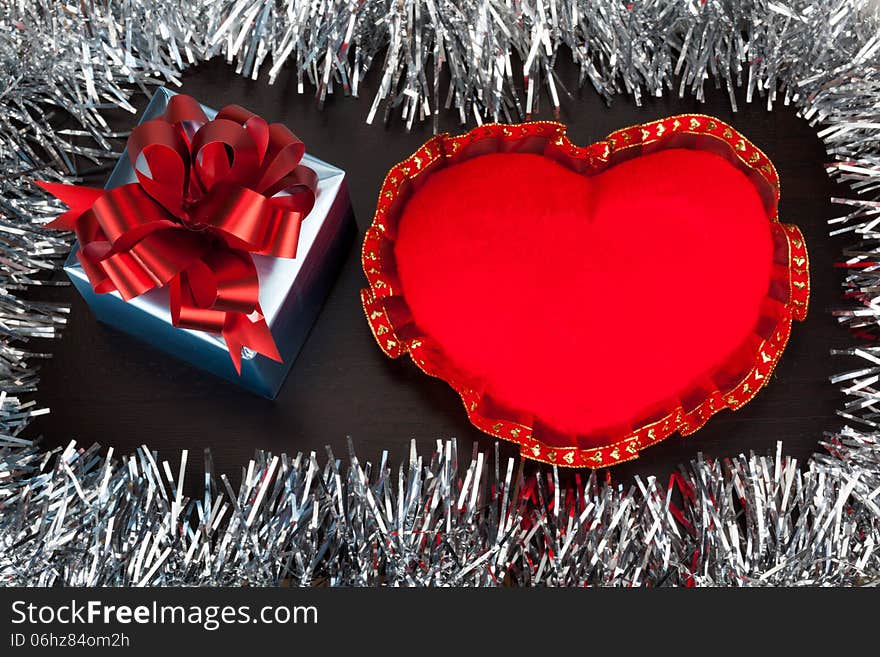 Valentine gift box with heart shape toy on wooden background with festive glitter