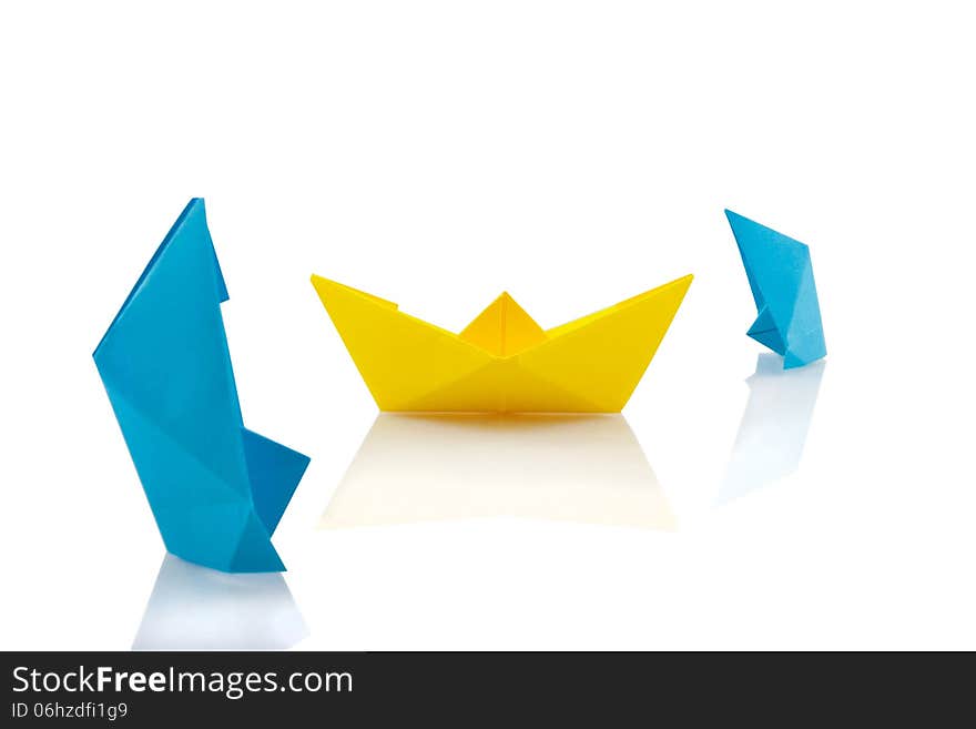 Yellow paper ship among two sinking blues. Yellow paper ship among two sinking blues.