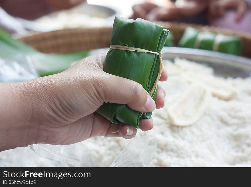 Glutinous rice, wrap with banana leaf in hand.