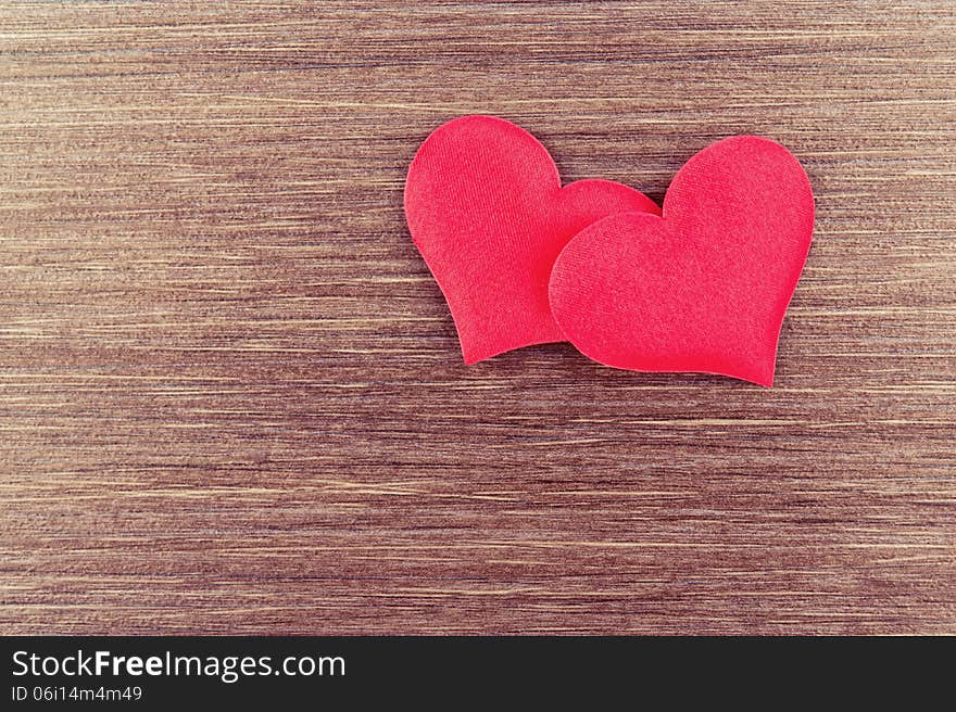 Two red hearts on a wooden  board