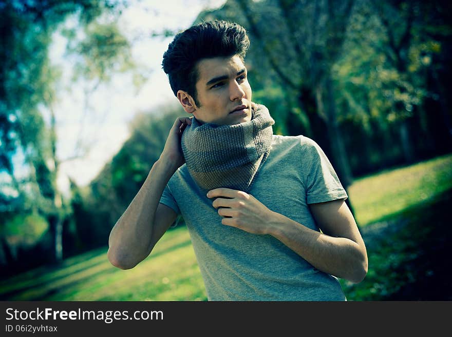 Attractive young handsome man, model of fashion in the park