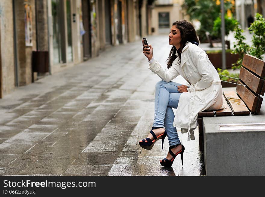 Portrait of beautiful young woman in urban background talking on phone