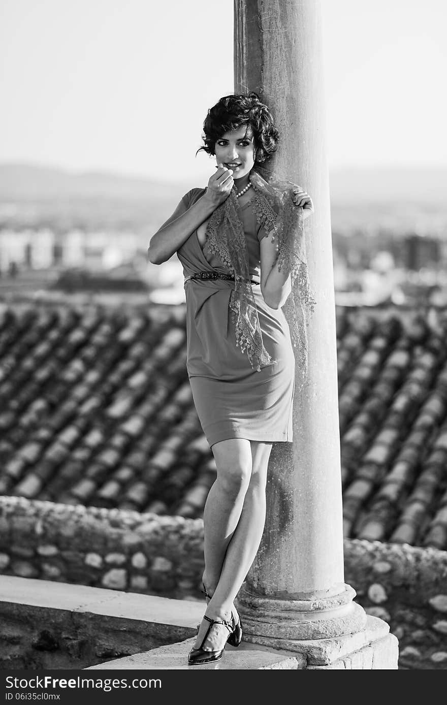 Portrait of a pretty woman, vintage style, in urban background, wearing a red dress. Portrait of a pretty woman, vintage style, in urban background, wearing a red dress