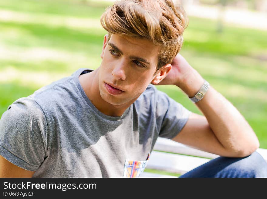 Portrait of a young handsome man, model of fashion, with modern hairstyle in urban background. Blonde hair. Portrait of a young handsome man, model of fashion, with modern hairstyle in urban background. Blonde hair