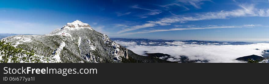 Mountain peak over a sea of clouds in winter