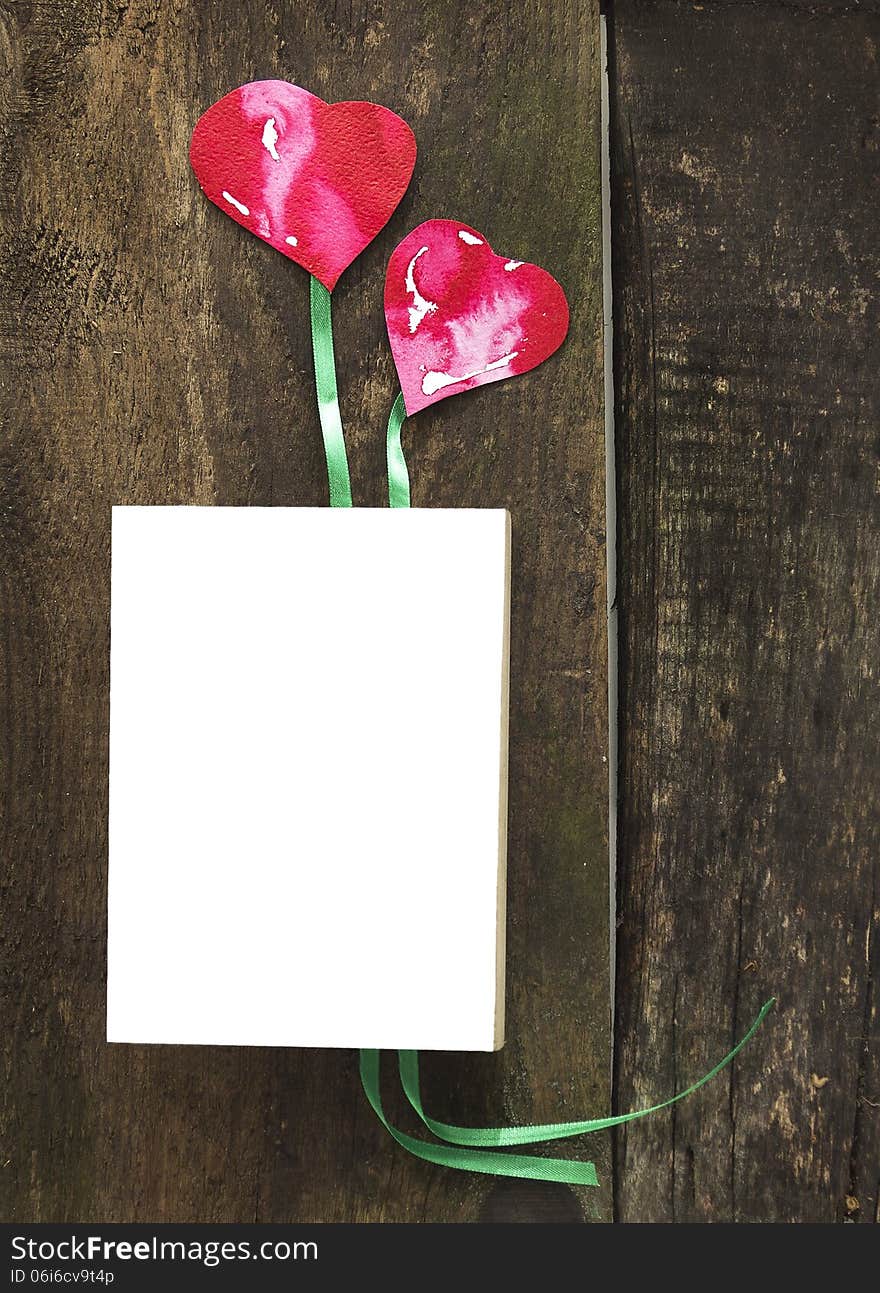 Book with two hearts laying on old boards