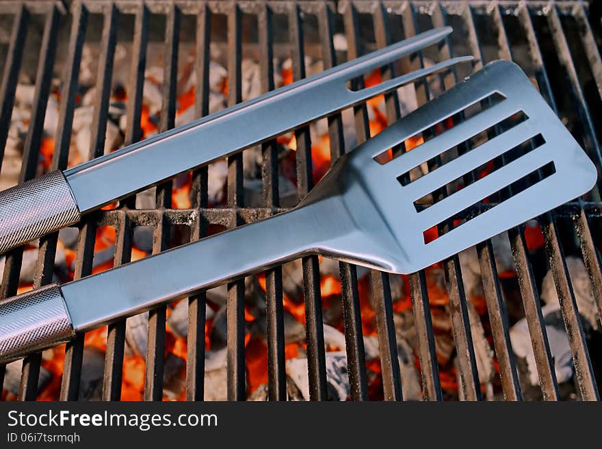 BBQ facilities and Spatula with fork on a Hot Cast Iron Grill. BBQ facilities and Spatula with fork on a Hot Cast Iron Grill