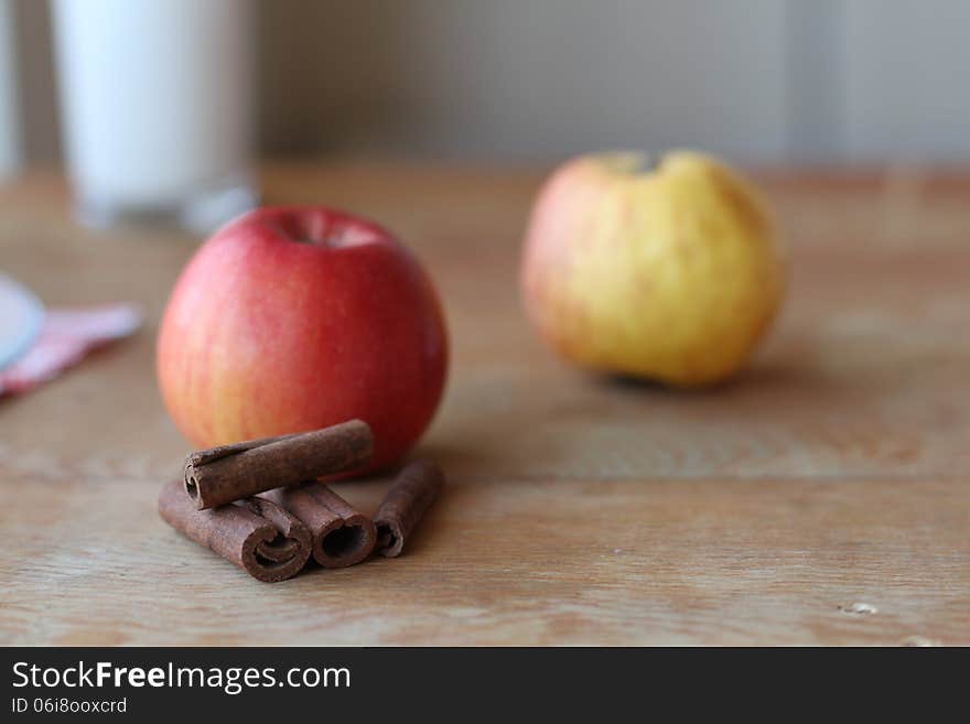 Apples with cinnamon sticks on the table