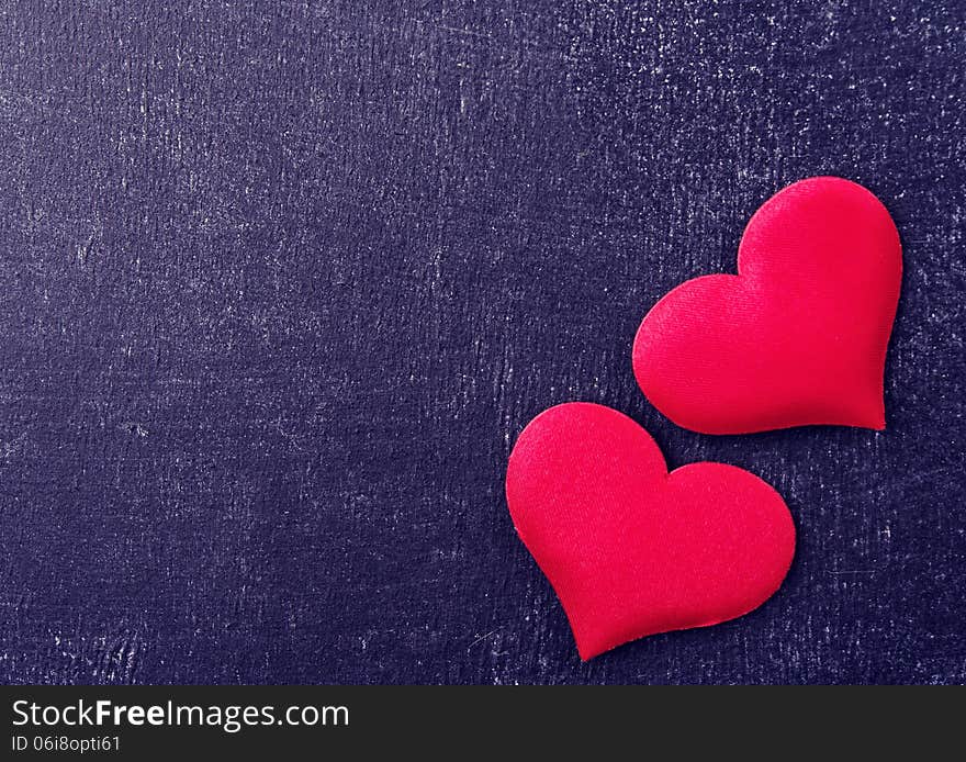 Valentine card. two red hearts on a black board