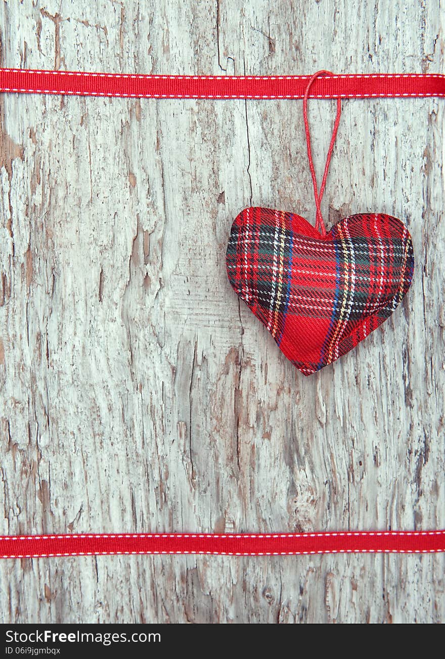 Valentine card with textile heart on old wood background