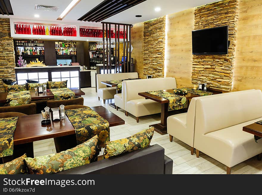 Modern restaurant interior with tables and sofas