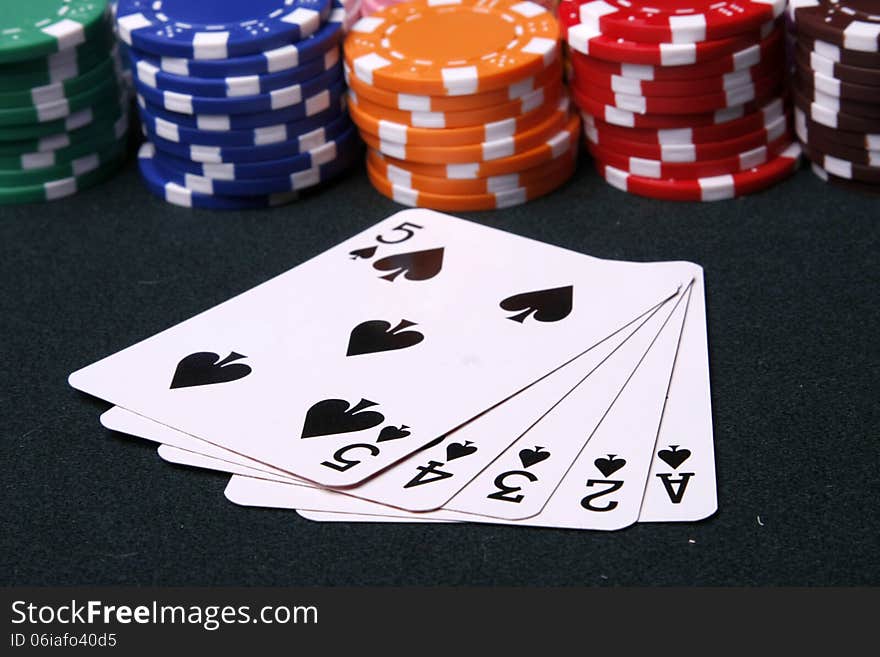 Colorful plastic chips and spade flush on the table. Colorful plastic chips and spade flush on the table.