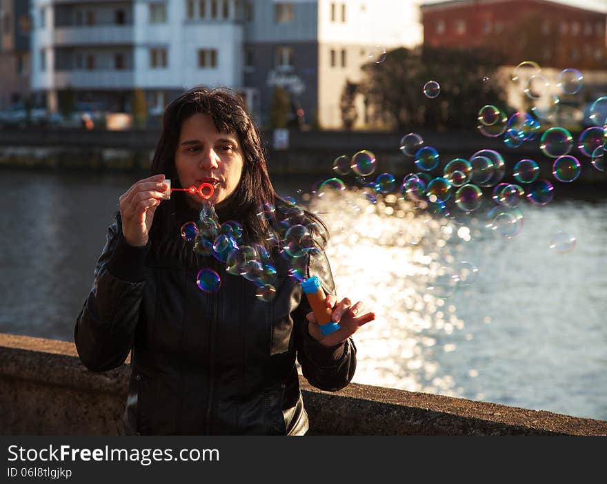 Young beautiful woman blows bubbles outdoor