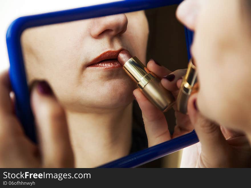 Woman Paints Lips With Lipstick Before A Mirror