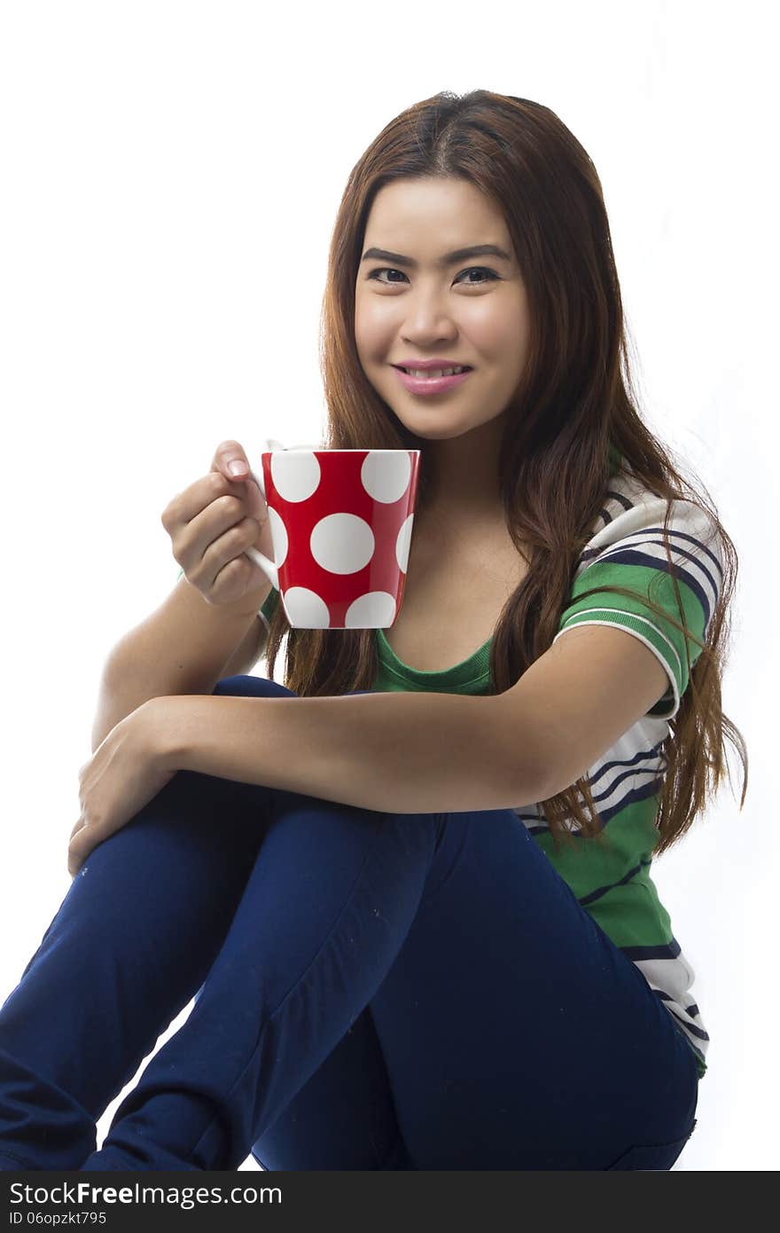 Portrait of Asian young woman sitting of the floor and holding Coffee cup isolated