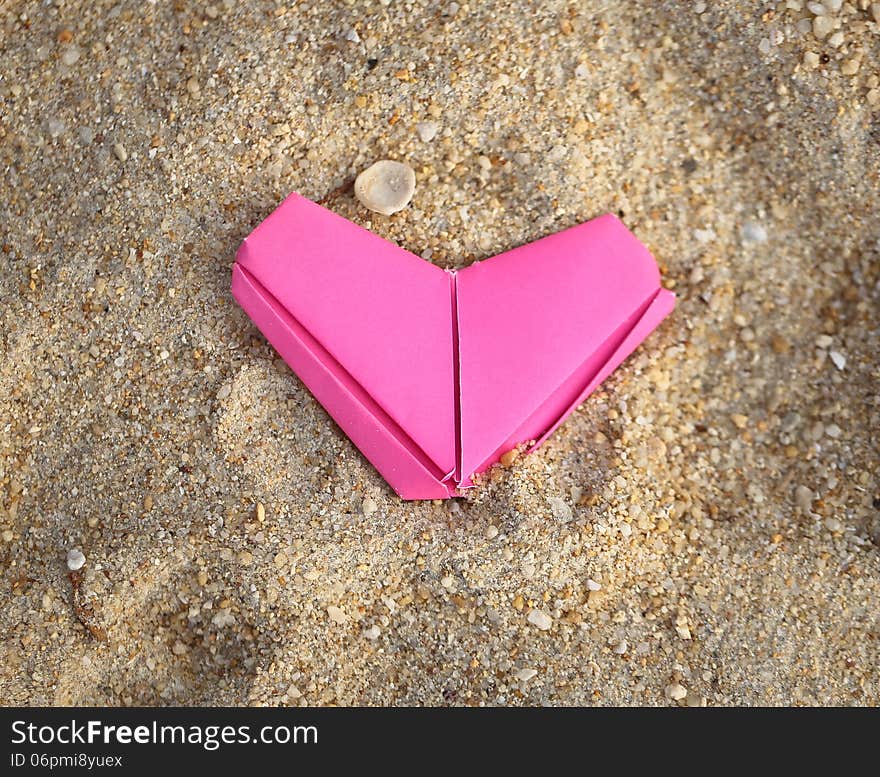 Festive pink paper heart on the beach. Festive pink paper heart on the beach