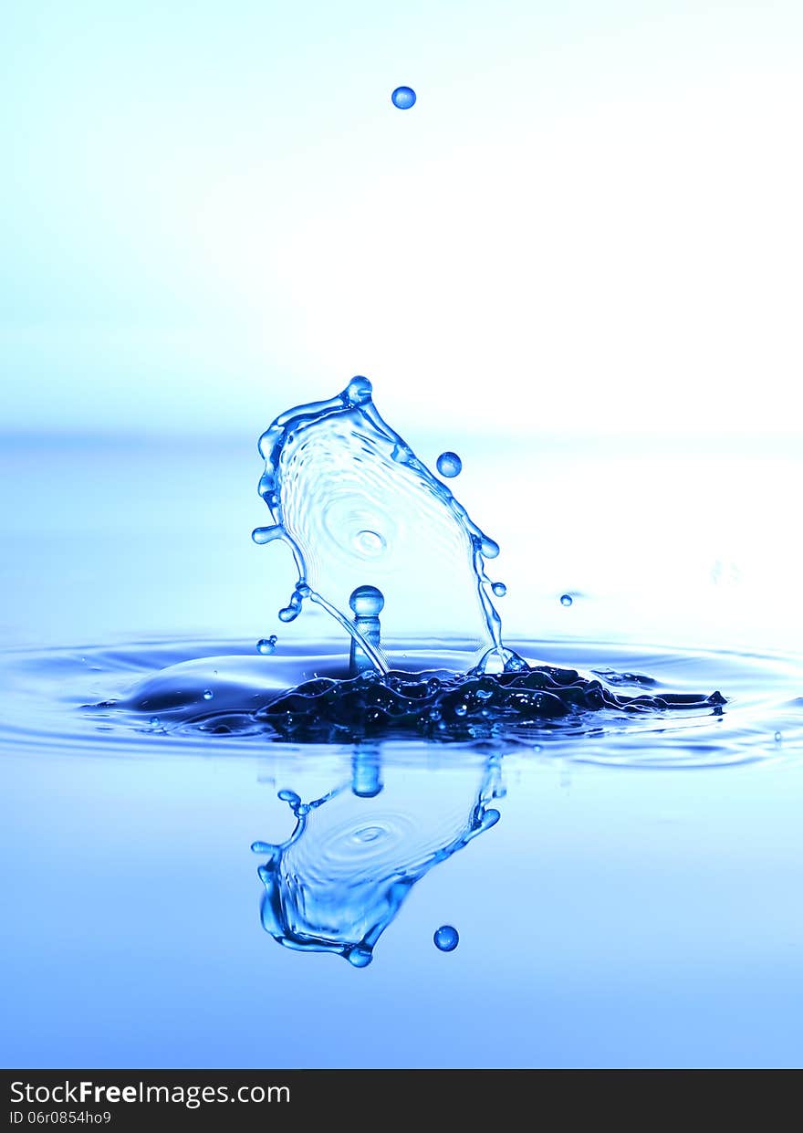 Splashing water drops on color background.Color waterdrops collide each other.