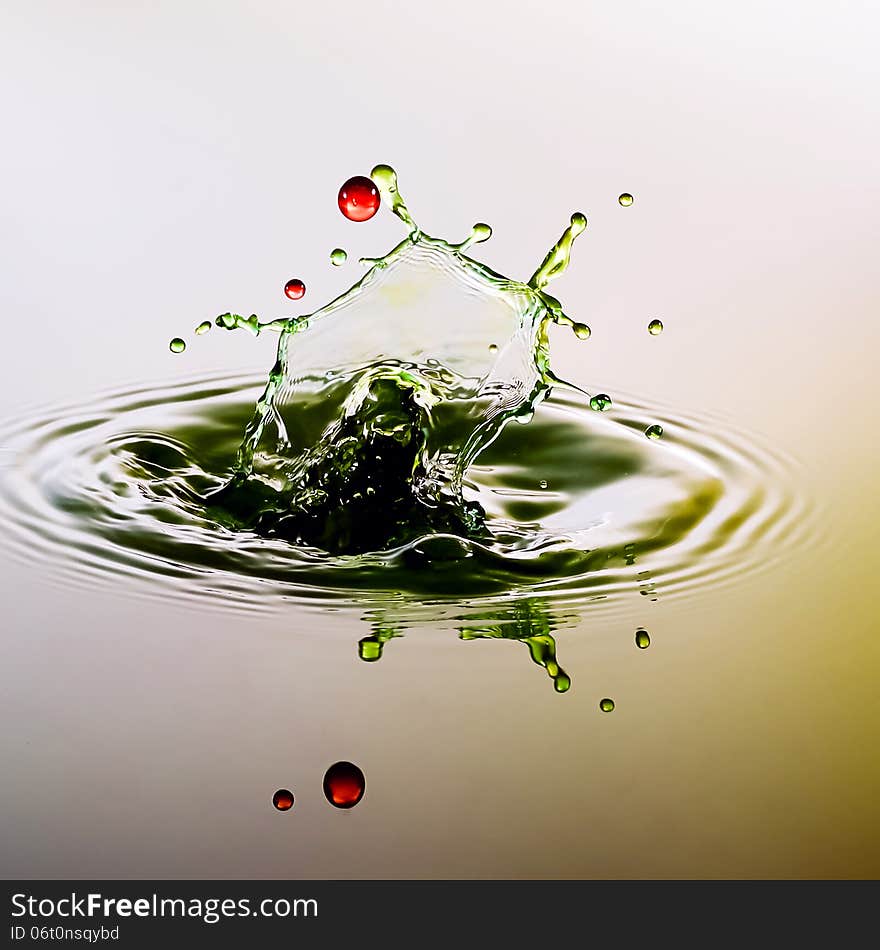 Splashing water drops on color background.Color waterdrops collide each other.