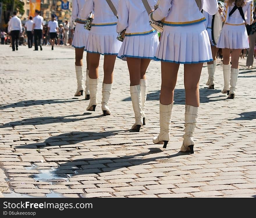 Drummer girls march on city street on summer day