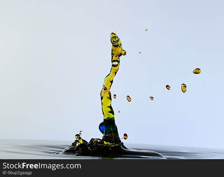 Color waterdrops collide each other against gray background and shaped a snake. Color waterdrops collide each other against gray background and shaped a snake.