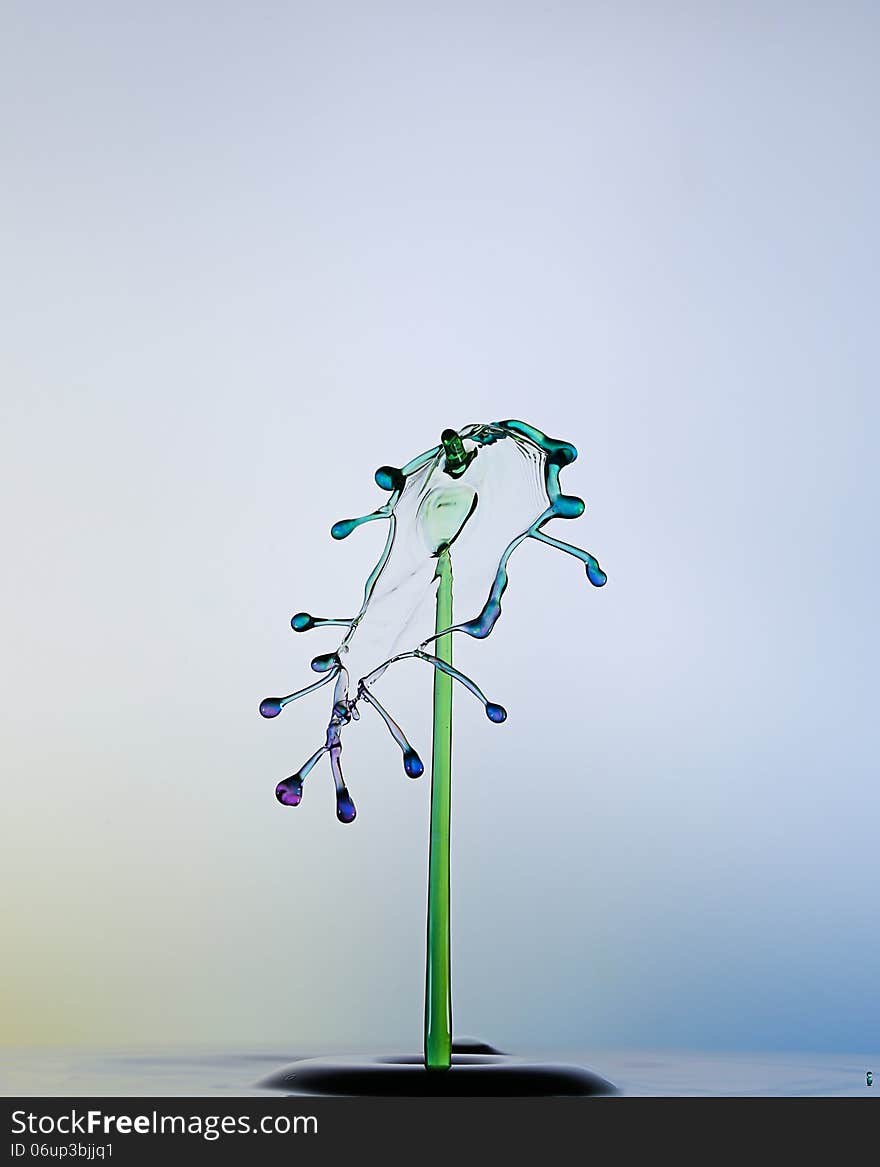 Blue and green waterdrops collide each other.