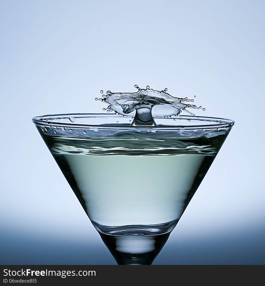 Water Drop Splash on the Champagne glass,splash water isolated on a gray background. Water Drop Splash on the Champagne glass,splash water isolated on a gray background.