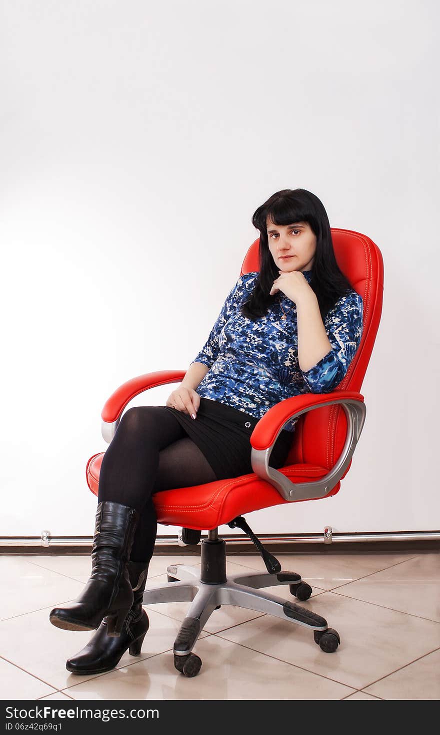 Young beautiful woman posing sitting on a red chair