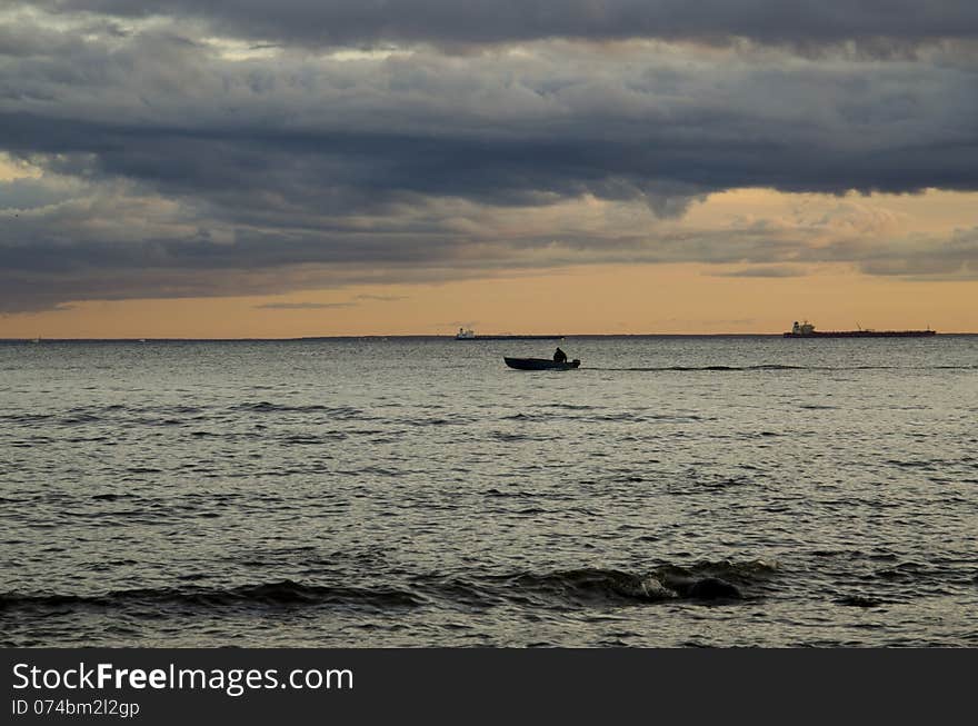 Fishing at sunset. Ships in the background. Fishing at sunset. Ships in the background.