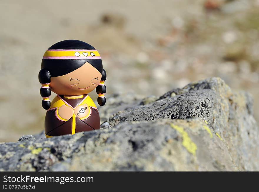 Native Indian Momiji Doll sitting on a rock